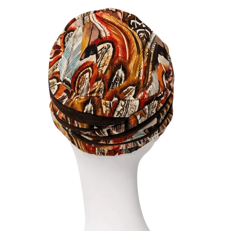 Shanti-turbaani Tribal Feathers -kuviolla mallinukella, takaa. Näyttää turbaanin muodon ja tummanruskeat nauhat